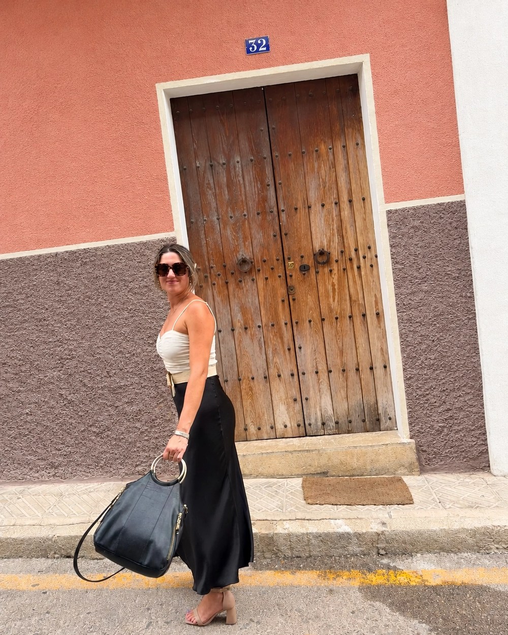 Valentina Panissa caminando frente a la puerta de madera de una casa mallorquina