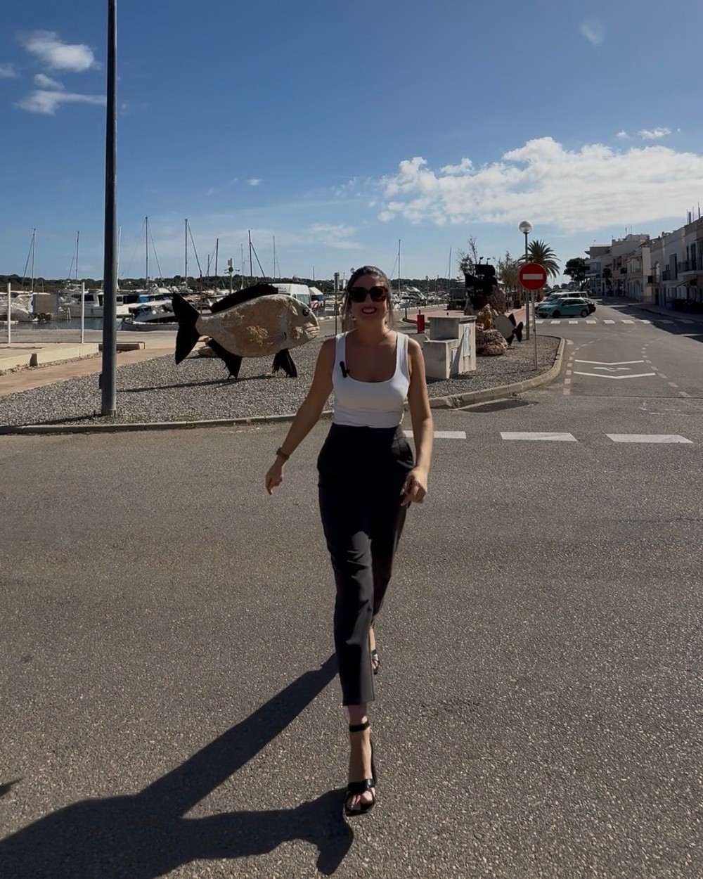 Valentina Panissa caminando frente al puerto deportivo de Mallorca, con los veleros al fondo