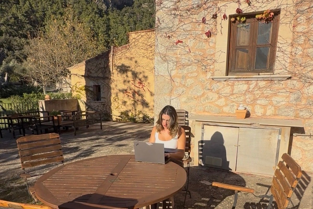 Valentina Panissa revisando documentación con el portátil en la terraza de una finca de Mallorca